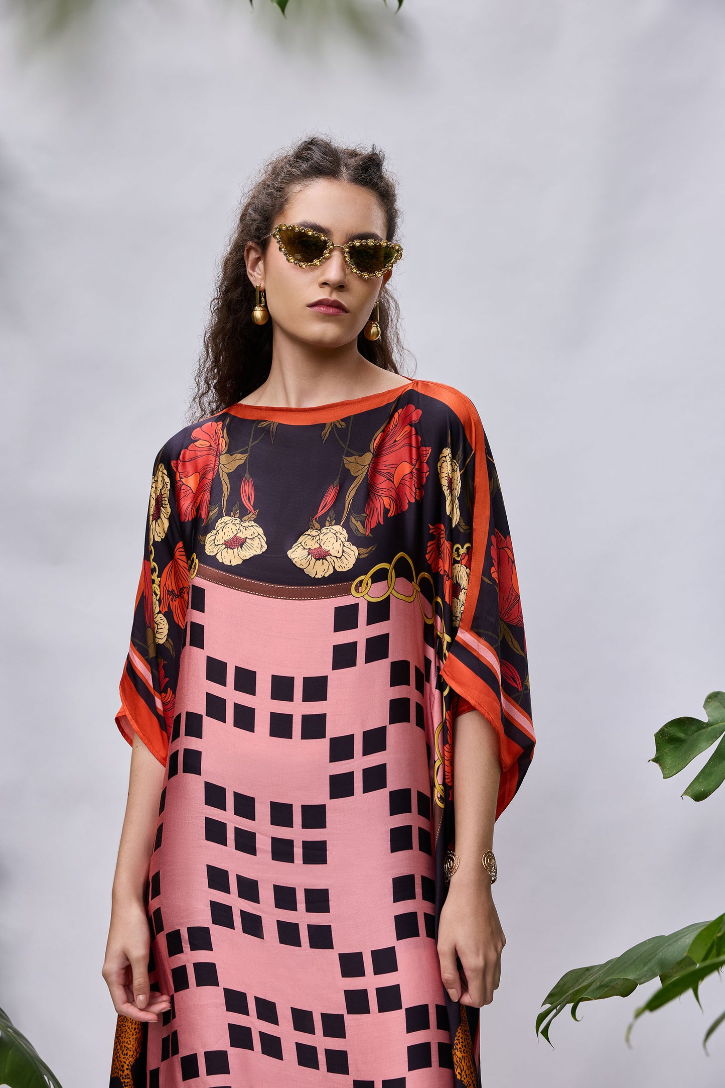 Model wearing Rosette Kaftan — flowy resort wear dress in coral and purple print