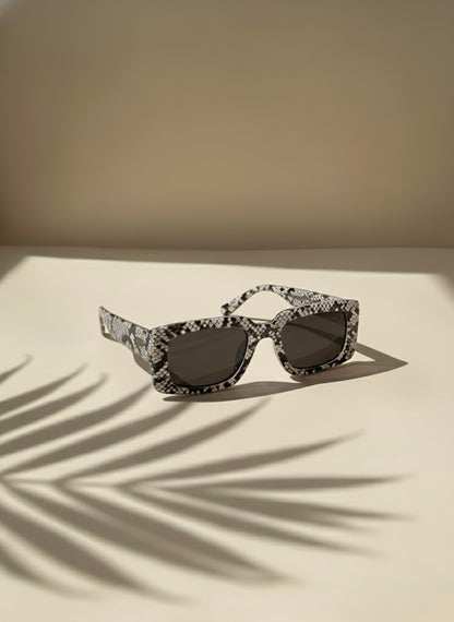Snakeskin-pattern rectangular sunglasses with dark lenses placed under palm shadows — Black Mojito Sunglasses by VA RA.