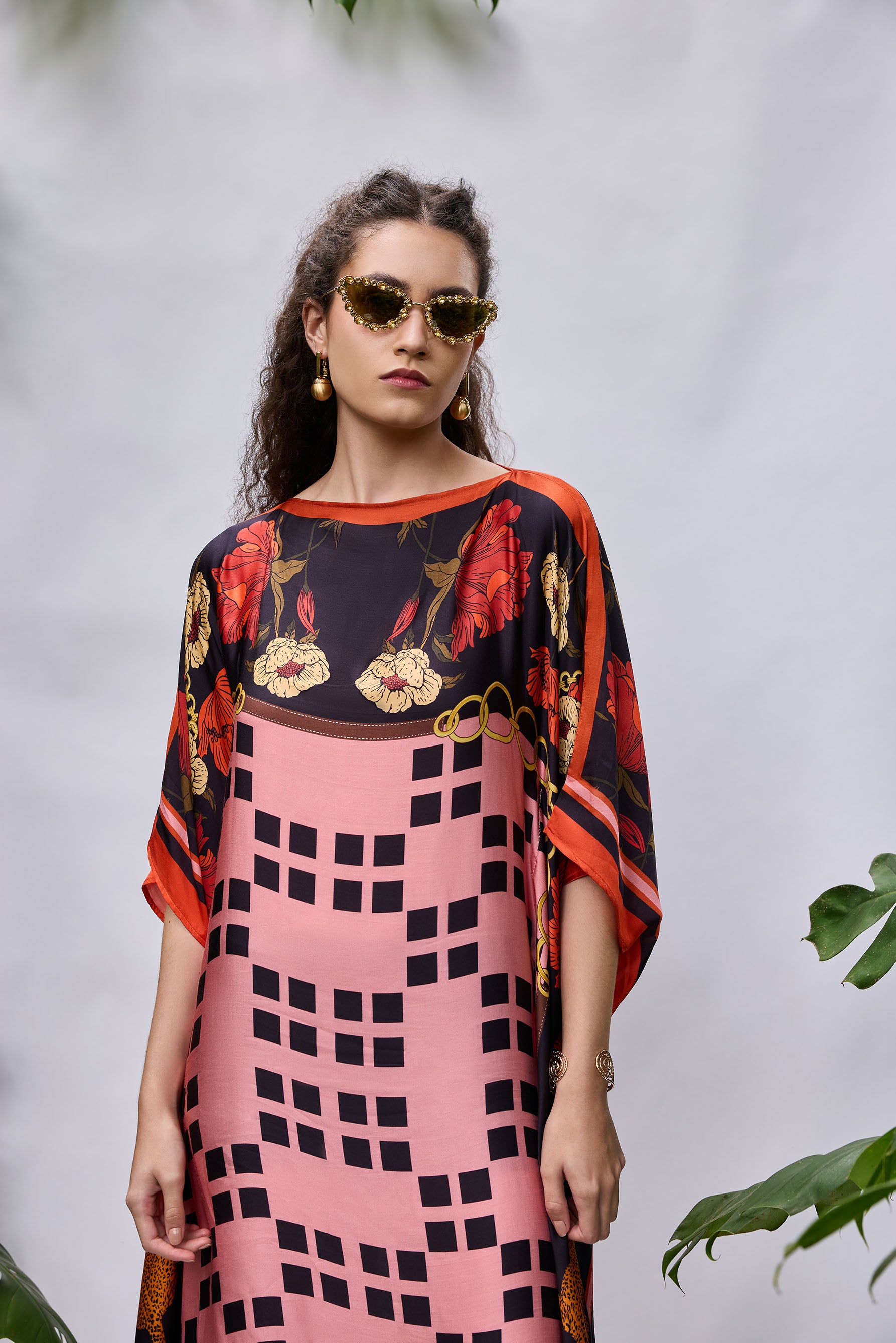 Model wearing Rosette Kaftan — flowy resort wear dress in coral and purple print