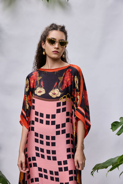 Model wearing Rosette Kaftan — flowy resort wear dress in coral and purple print