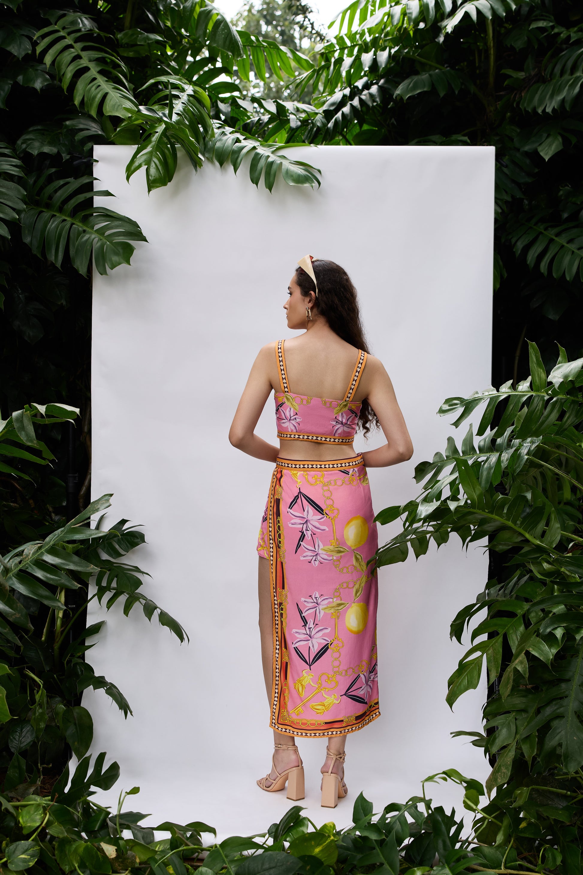 Back view of Lilly Bloom Co-ord Set — strappy crop top and high-slit skirt in pink satin