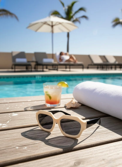 Close-up of ivory frame sunglasses with black temples in soft sunlight with palm leaf shadows — VA RA White Negroni Sunglasses.